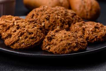 Tasty fresh oat cookies on a dark concrete background