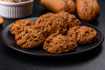 Tasty fresh oat cookies on a dark concrete background