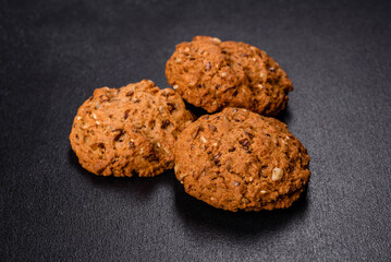 Tasty fresh oat cookies on a dark concrete background
