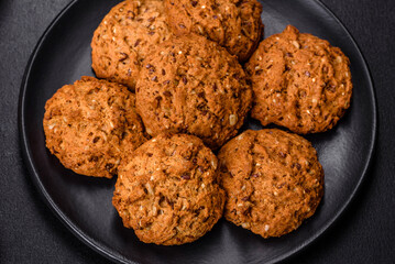 Tasty fresh oat cookies on a dark concrete background