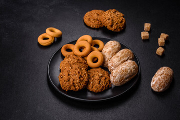 Tasty fresh oat cookies on a dark concrete background