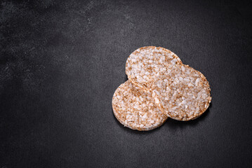 Three round crunchy buckwheat crispbread on a dark concrete background