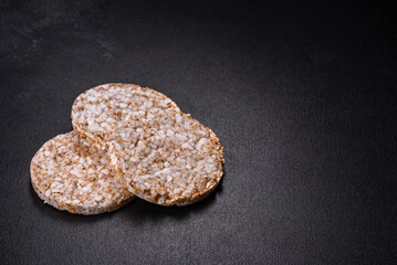 Three round crunchy buckwheat crispbread on a dark concrete background
