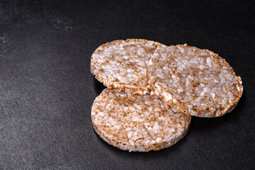 Three round crunchy buckwheat crispbread on a dark concrete background