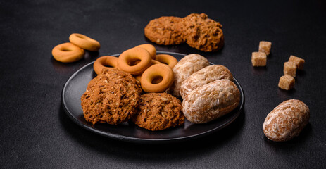 Tasty fresh oat cookies on a dark concrete background