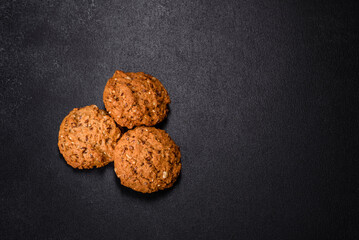 Tasty fresh oat cookies on a dark concrete background