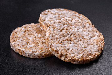 Three round crunchy buckwheat crispbread on a dark concrete background