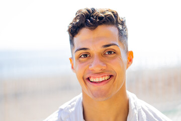 Young hispanic man 20- 25 years old smiling happy looking to the camera outdoors - obrazy, fototapety, plakaty