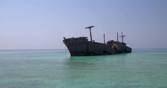 ship wreck stranded near shore - old sunken ship stuck in coral reef  famous Greek ship wreck in Kish Island Iran , An old abandoned shipwreck in clear blue waters 