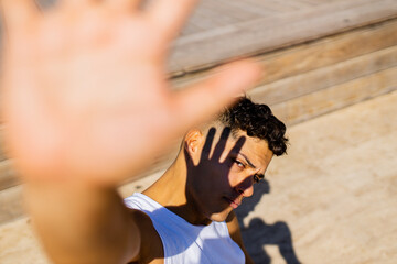 mixed race man hiding from the sun at sunny day outdoors