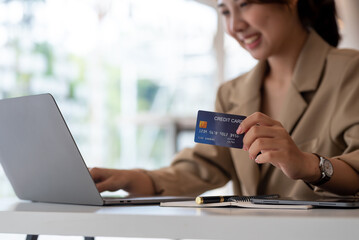 Businesswoman hand holding credit card and using laptop. Close up of female shopping online with credit card. Online Payment.