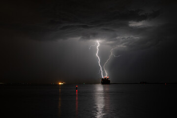 Lightning strikes at sea near a ship