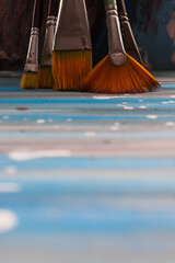 Paint brushes on a colorful background in the studio.