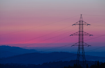 High voltage electric tower silhouette during sunset in Braga, Portugal.