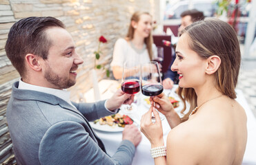 Men and women having a good time with food and drink in restaurant
