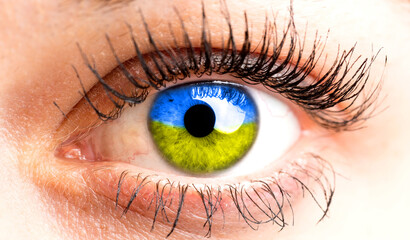 Ukrainian woman with a flag in his eye. End of war concept. Woman's eye gazing at Ukraine. Longing for her husband.