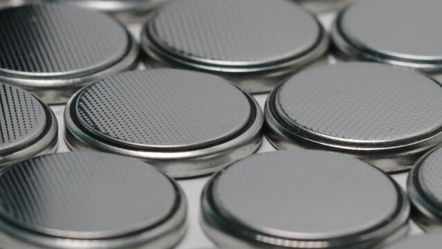CR2032 coin cell batteries background closeup pan slide