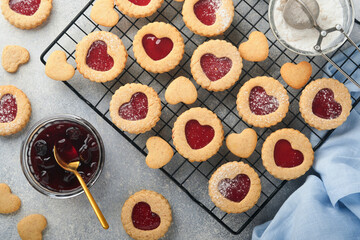 Traditional Linzer cookie with strawberry jam and powder sugar on light grey beautiful background. Top view. Traditional homemade Austrian sweet dessert food on Valentines Day. Holiday snack concept.