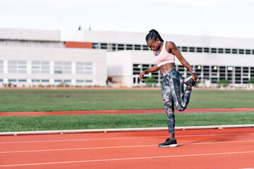 Athlete sprinter stretching her legs
