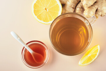 Ginger tea. Cup of ginger tea with lemon, honey and mint on beige background. Concept alternative medicine, natural homemade remedy for cold and flu. Top view. Free space for your text.