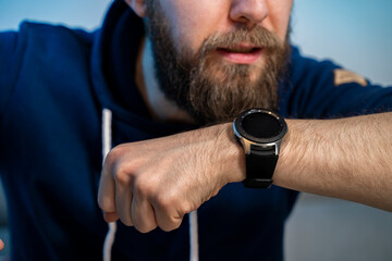 Young hipster man, talking in to smart watch closeup shot 