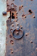 closeup of an old black rusty metal door at concrete wall