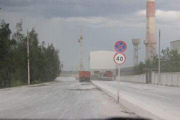 Big yellow dump truck on the background of an industrial cement factory. Concrete factory. Loading and transportation of minerals in the chalk mining quarry, Belarus, Krasnoselsk