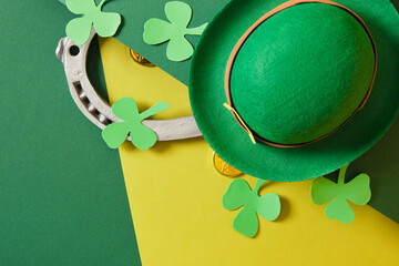 horseshoe, leprechaun hat, coins, cauldron and foamiran clover leaves on green background, st....