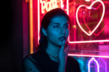 Neon close up portrait of young woman wear hoodie. night city street shot	