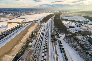 Fototapeta premium Aerial view of cargo train loaded with crushed sandstone materials at mine factory. Railway transportation of open pit mining ore