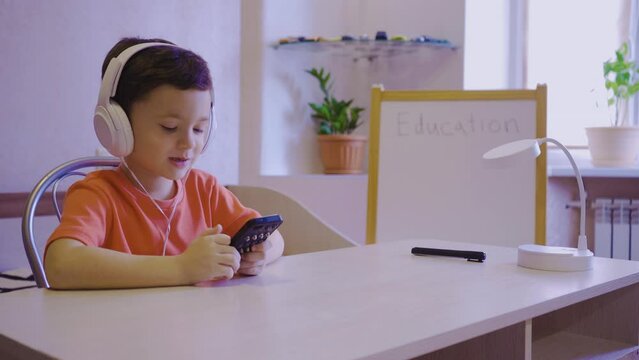 A little boy learns music at an online school and sends an air kiss