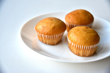 Sweet fluffy muffin buns on a white plate