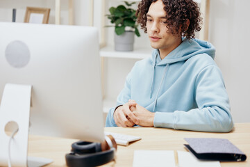 A young man sitting at a table in front of a computer freelance technologies