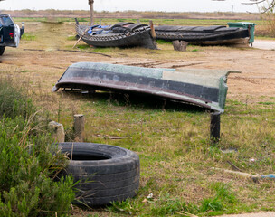 astillero de barcos de madera en suelo de tierra, con barcos viejos, varados en el puerto de Catarroja. la albufera de Valencia.