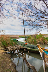 embarcadero del puerto de sollana en el parque natural de la albufera ,con barcas y cielo nublado .