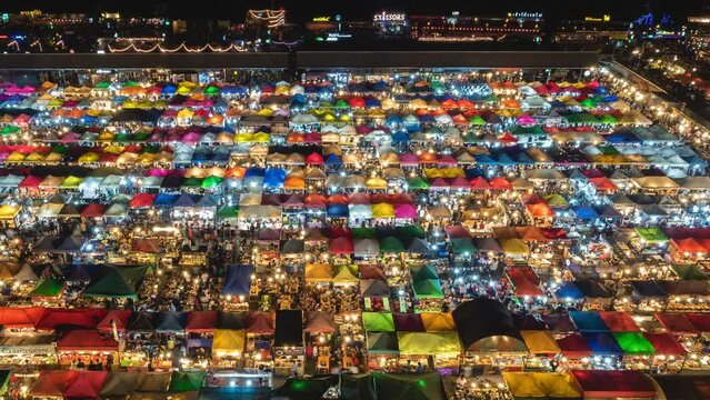 Time lapse view of colourful food stalls at the popular Ratchada Night Market in Bangkok, Thailand.	