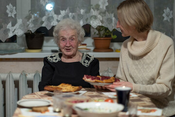 An old woman at the dinner table with her daughter. - 491105269