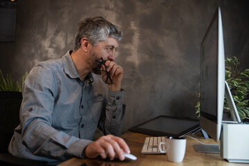 homme, employé de bureau ou homme d'affaire qui travaille à la maison avec son ordinateur. il est...