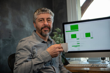 portrait d'un homme de 50 ans qui travaille devant un ordinateur dans son bureau. Il travaille à...