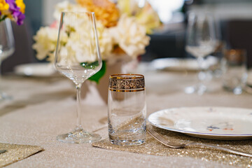 wine glass and beverage glasson served dining table with utensils and flowers