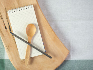 Blank recipe book, napkin and wooden spoon, top view. blank notepad for recipe Place for text