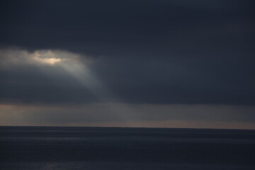 Ray light between the clouds over the ocean