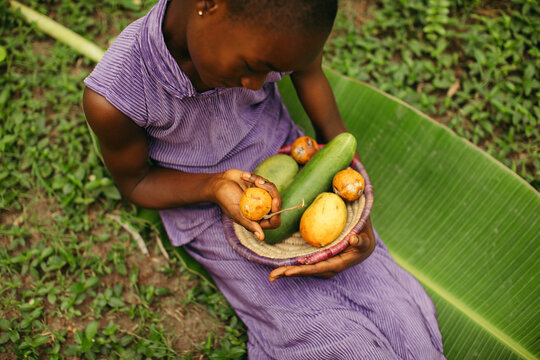 Portrait of a young African girl holding her harvest on the farm
