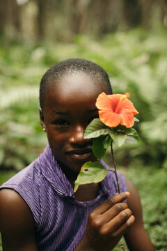 Beauty portrait of a young African girl holding a flower to her face