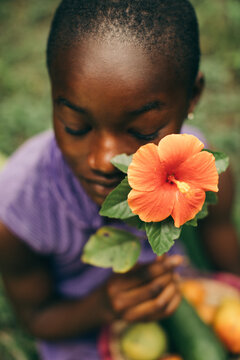 Beauty portrait of a young African girl holding a flower to her face