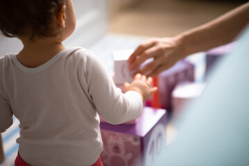 white female child plays with toys at home blurred background, view from behind, love positive - obrazy, fototapety, plakaty