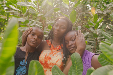 Family portrait of black african activists standing within nature holding each other 