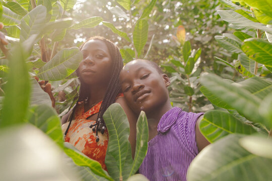 Portrait of a black african mother and daughter farmer standing within nature under the sunlight 