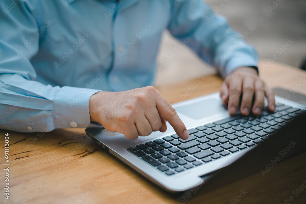 Poster closeup image of a business man's hands working and typing on laptop computer keyboard on office tab