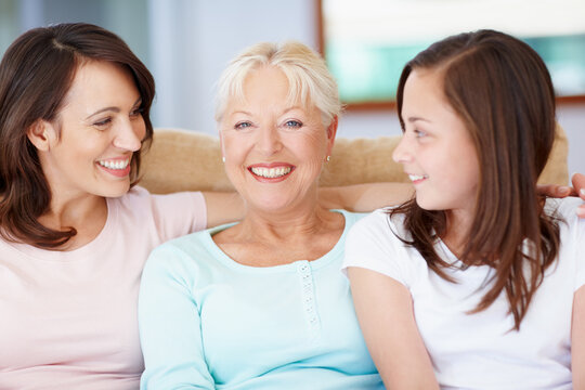 A proud grandmother. A happy grandmother sitting with her daughter and granddaughter smiling widely.
